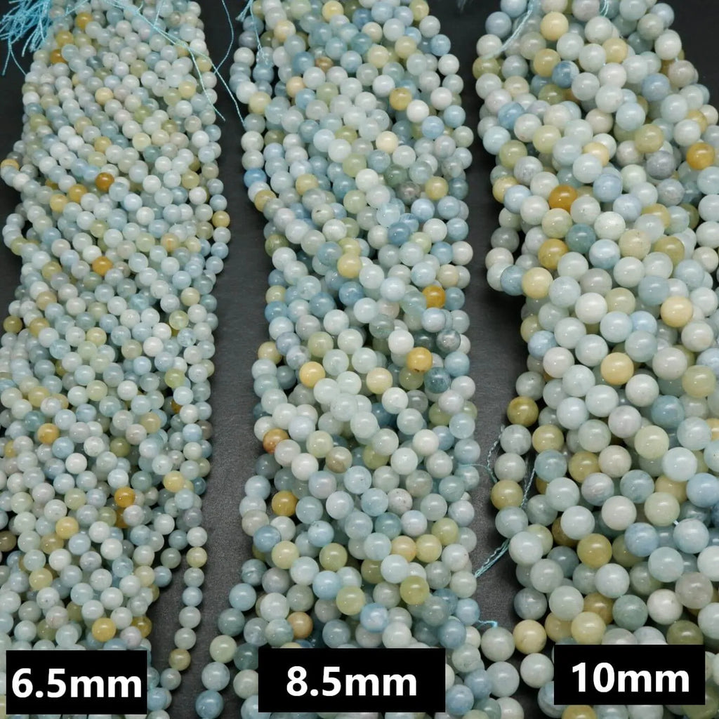 Multicolor aquamarine beads. Polished round blight to dark blue beads with the occasional light yellow beads mixed in.